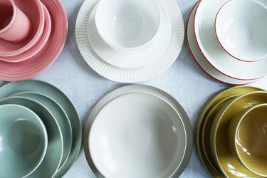 A selection of dinnerware place settings on a grey surface