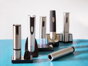 Six electric corkscrews on a blue countertop 