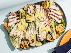 Grilled chicken caesar salad on a platter.