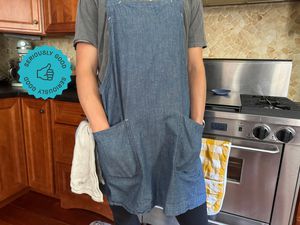 A person wearing a blue smock apron.