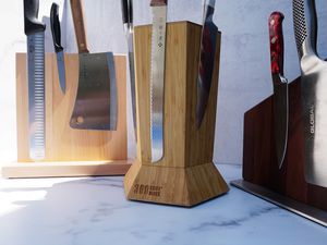 three knife blocks with knives on it on a marble surface