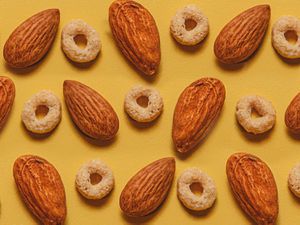 Overhead view of circle shaped cereal pieces and almonds arranged in an alternating patter