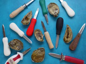 oyster knives on a blue surface with oysters