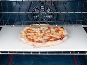 a pizza cooking on a pizza stone