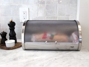 A bread box with a loaf of bread in it and its lid closed.