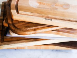 A stack of carving boards on a marble surface