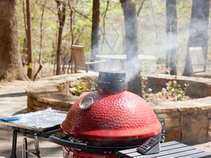 a shot of a kamado cooker billowing smoke