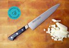 the misono chef knife on a cutting board with diced onion