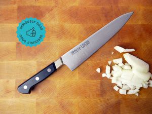 the misono chef knife on a cutting board with diced onion