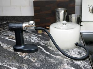 the breville polyscience cocktail smoker on a marble countertop with a cloche filled with smoke