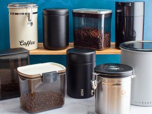 Numerous coffee canisters holding coffee on a kitchen countertop.