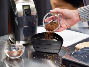 Person sifting coffee for the Baratza Virtuoso + Conical Burr Coffee Grinder