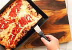 Deep dish pizza being served out of a deep dish pizza pan