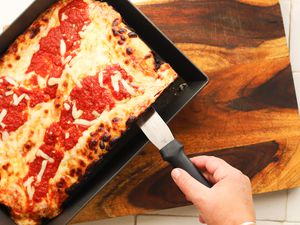 Deep dish pizza being served out of a deep dish pizza pan