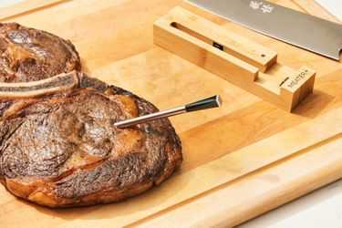 The Meater Plus Smart Meat Thermometer with Bluetooth stuck into a piece of lamb displayed on a cutting board