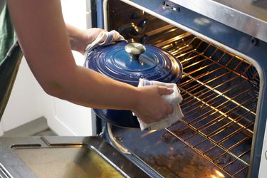 a person moving a dutch oven into the oven