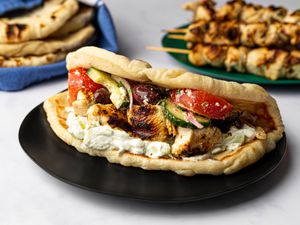 Skewers served with salad, pita, and tzatziki sauce