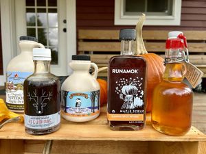 A collection of maple syrup bottles on a crate