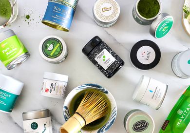 Numerous matcha powders on a marble countertop.