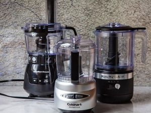 Three mini food processor on a marble kitchen countertop.