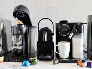 A number of Nespresso machines on a marble countertop.