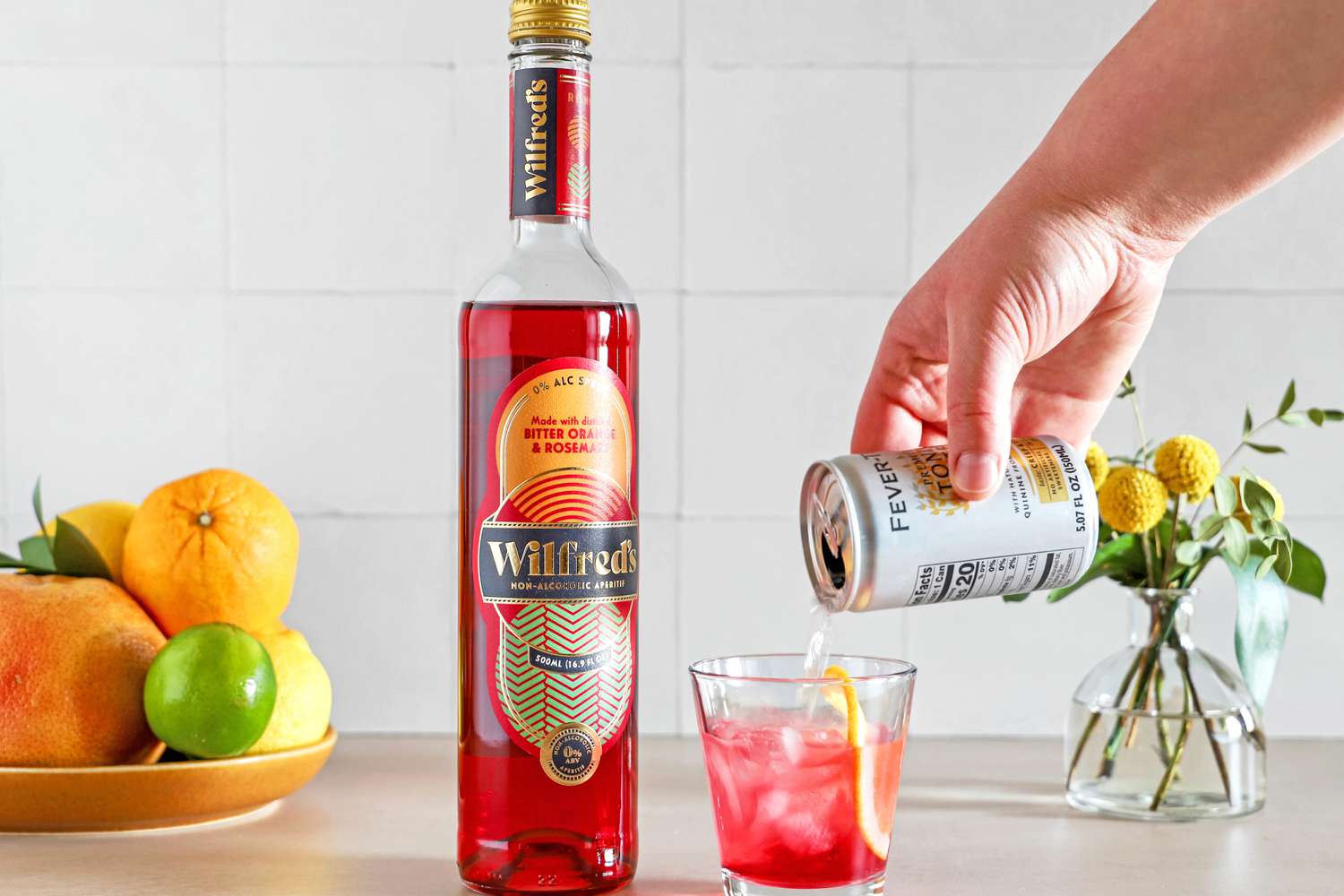 Person pouring liquid into glass of Wilfred's Non-Alcoholic Bittersweet Aperitif