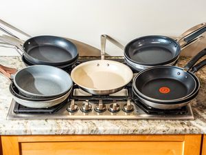 A bunch of pans stacked on a gas stove