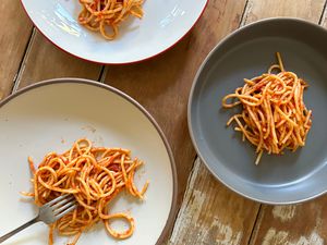 An overhead shot of three pasta bowls filled with spaghetti.