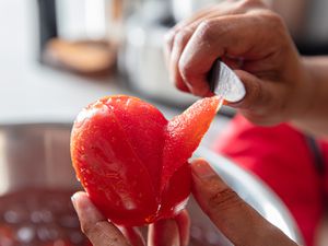 Peeling a tomato with a knife.