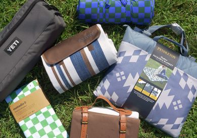 six picnic blankets folded up on grass