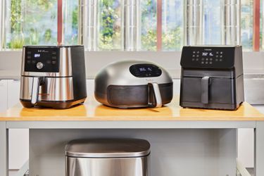 Three air fryers on a kitchen countertop.