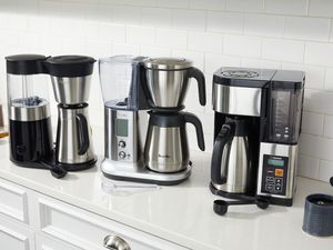 three coffee makers on a kitchen countertop 