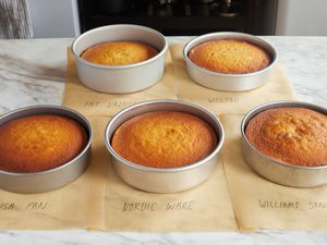 five cake pans with cakes in them on a kitchen countertop