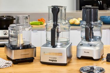 Three food processors on a kitchen countertop. 