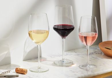 three wine glasses filled with different types of wine