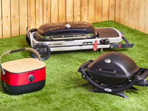 three portable gas grills on a grassy surface