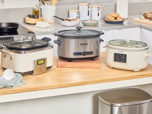 Three slow cookers on a kitchen counter