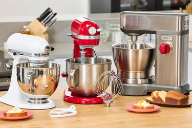 Three stand mixers on a kitchen countertop.