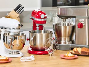 Three stand mixers on a kitchen countertop.