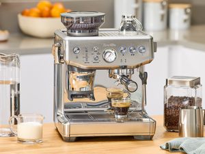 The Breville Barista Express Impress on a kitchen countertop.