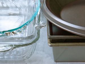 a stack of metal pans on the right and a stack of glass pans on the left