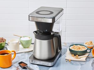 OXO Brew 8-Cup Coffee Maker displayed on a kitchen counter with breakfast food and mug of coffee