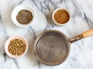 A mesh-covered spice toaster surrounded by spices