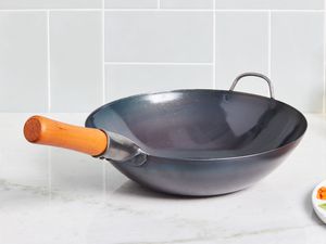 a carbon steel wok on a marble kitchen surface