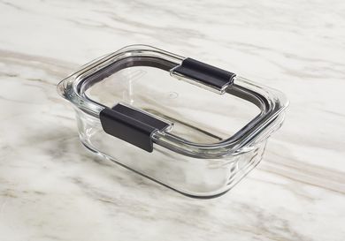 A glass food storage container on a marble surface