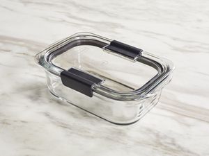 A glass food storage container on a marble surface