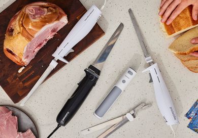 a variety of electric knives on a melamine countertop with ham and a piece of bread