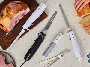 a variety of electric knives on a melamine countertop with ham and a piece of bread