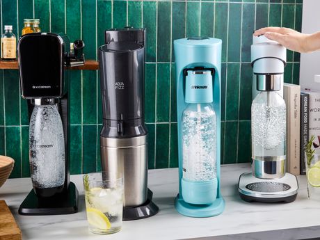 Four soda makers on a kitchen countertop.