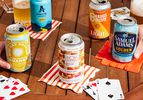 a variety of non alcoholic beers on a table with napkins and cards